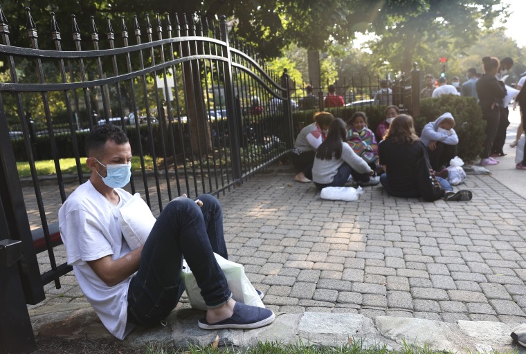 Migrantes de Centro y Sudamérica esperan cerca de la residencia de la vicepresidenta Kamala Harris, luego de ser despachados allí el 15 de septiembre de 2022 en Washington, DC.