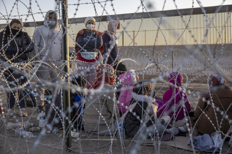 Inmigrantes esperan ser procesados por agentes de la Patrulla Fronteriza en un campamento cerca de la valla fronteriza entre EE.UU. y México el 12 de mayo de 2023 en El Paso, Texas.