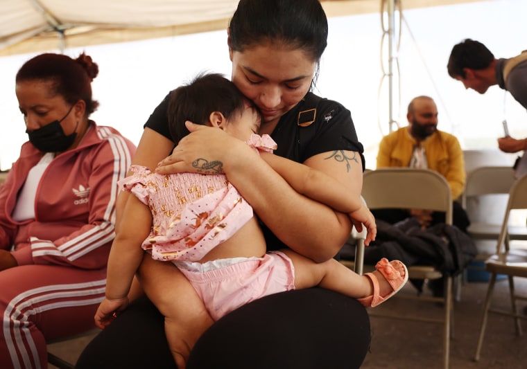 La madre inmigrante Andrea, de Ecuador, sostiene a su hija Mia, de 9 meses, en un centro de transición de migrantes para solicitantes de asilo liberados de la custodia de la Patrulla Fronteriza después de cruzar a Estados Unidos, el 12 de mayo de 2023 en Somerton, Arizona. Andrea dijo que habían viajado durante 10 días desde Ecuador a EE.UU. 