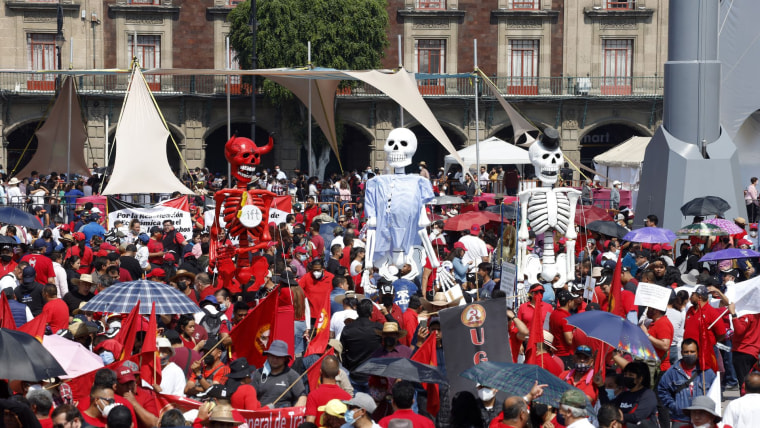 Una multitud usando colores rojos está reunida en una plaza de Ciudad de México para una manifestación por el Día de Trabajo del 1 de mayo. 