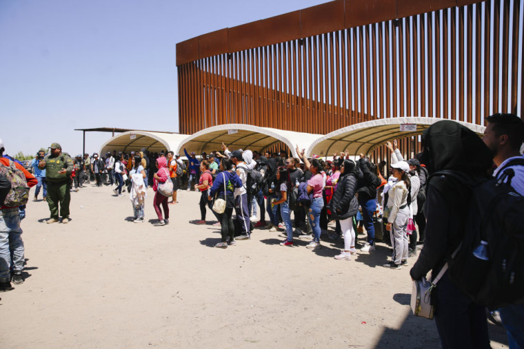 Decenas de migrantes esperan a ser procesados en Yuma, Arizona, el 11 de mayo de 2023, día en el que expiró el Título 42.