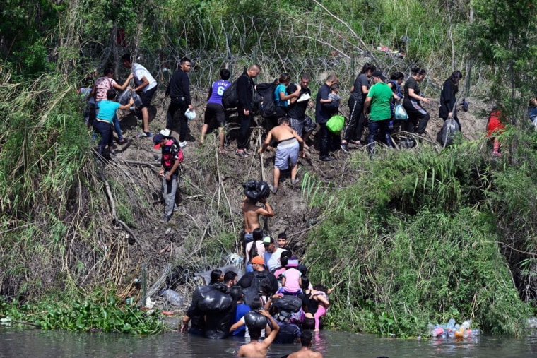Migrantes intentan llegar a Estados Unidos a través del Río Grande, reforzado con una cerca de alambre de púas, desde la ciudad mexicana de Matamoros, en el estado de Tamaulipas, el 10 de mayo de 2023.