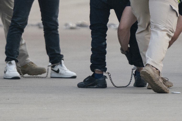 Migrantes guatemaltecos son revisados antes de subir esposados de manos y pies a vuelos de deportación en Harlingen, Texas, el 5 de mayo de 2023.