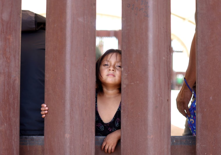 Janina, una migrante ecuatoriana de 4 años, apoya su cabeza en el muro fronterizo a la espera de ser procesada por agentes estadounidenses junto a sus padres en Yuma, Arizona. Su padre aseguró que la familia viajó durante seis semanas desde Ecuador y fue secuestrada con más de 100 inmigrantes en San Luis Río Colorado, México, antes de ser rescatados por las autoridades mexicanas.