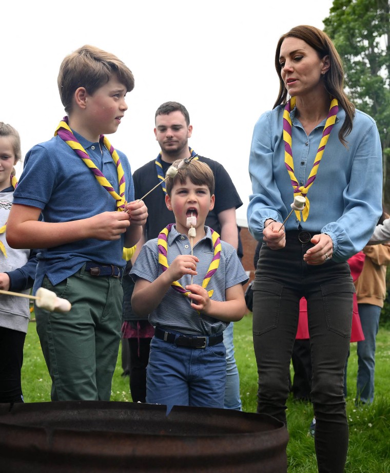 Britain's Prince George of Wales, Britain's Prince Louis of Wales and Britain's Catherine, Princess of Wales toast marshmallows as they take part in the Big Help Out, during a visit to the 3rd Upton Scouts Hut in Slough, west of London on May 8, 2023, where the family joined volunteers helping to renovate and improve the building. 