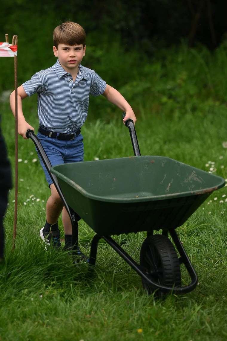 Prince Louis of Wales takes control of a wheelbarrow as he helps his parents take part in the Big Help Out, during a visit to the 3rd Upton Scouts Hut in Slough, west of London on May 8, 2023, where they joined volunteers helping to renovate and improve the building. 