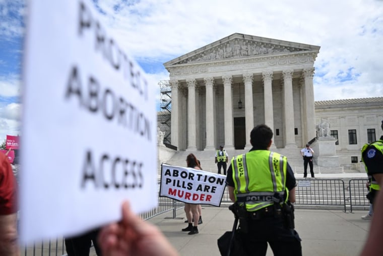 Una persona protesta a favor del derecho al aborto mientras otras lo hacen en contra ante la Corte Suprema en Washington, DC, el 15 de abril de 2023.