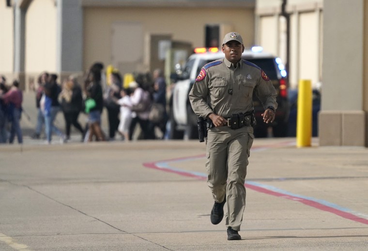 Un agente corre afuera del centro comercial Allen Premium Outlet en Texas, el 6 de mayo de 2023.