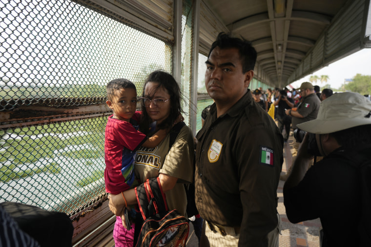 Escoltados por oficiales migratorios de México, un grupo de 50 de migrantes cruzó el puente fronterizo Puerto Nuevo desde Matamoros, México en la mañana del viernes 12 de mayo para ser procesados por oficiales estadounidenses. 