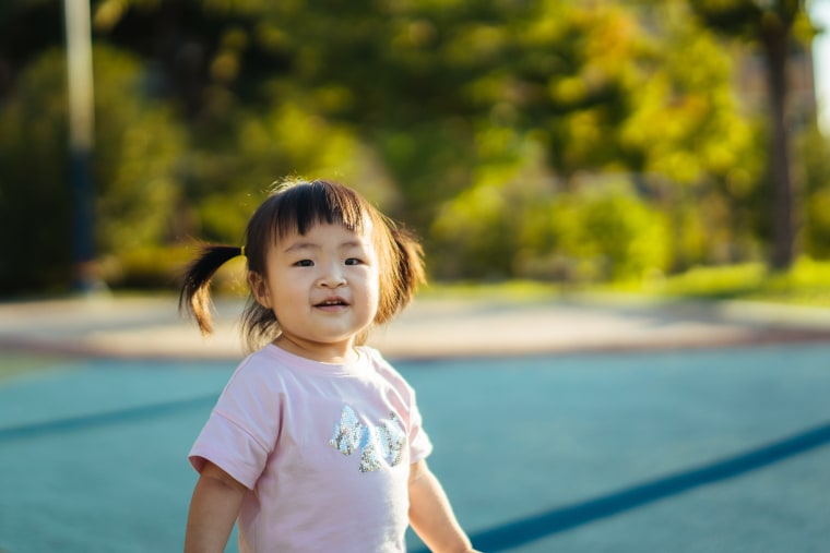 Baby girl running through playground