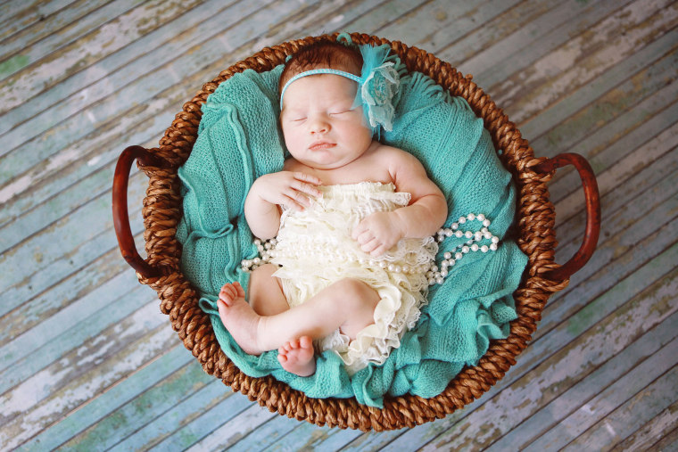 Newborn Baby Girl Sleeping in a Basket