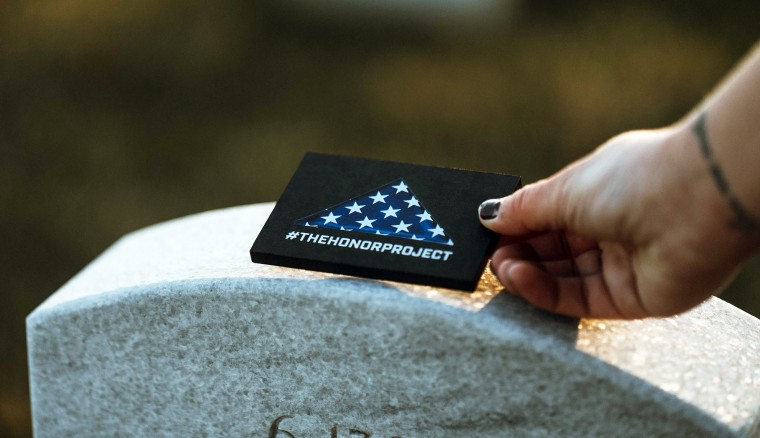 "Their sacrifice is why we have this incredible free country," Honor Project co-founder Emily Domenech says. A volunteer with The Honor Project visits a service member's grave on a previous Memorial Day.
