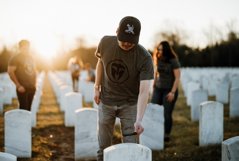 A volunteer pays respects to a fallen soldier as part of "The Honor Project" initiative in past years.