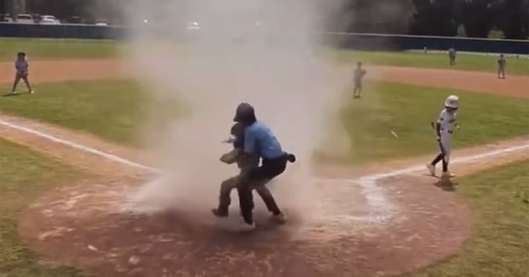 Umpire pulls young baseball player from dust storm