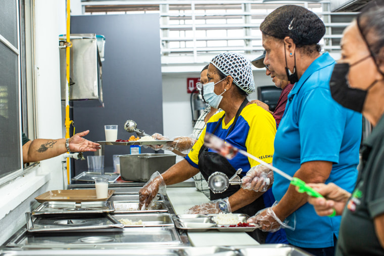 Workers serve lunch at the Center for Activities and Multiple Uses for the Elderly of Toa Baja in Toa Baja, Puerto Rico, on May 26, 2023.