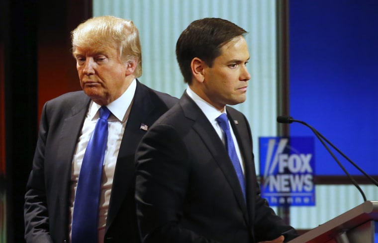 Then-presidential candidate Donald Trump passes behind Sen. Marco Rubio during a commercial break at a primary debate