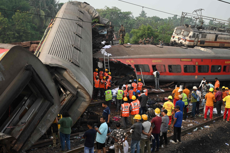 Rescue workers gather around damaged carriages at the accident site of a collision near Balasore in the eastern state of Odisha, on June 3, 2023.  