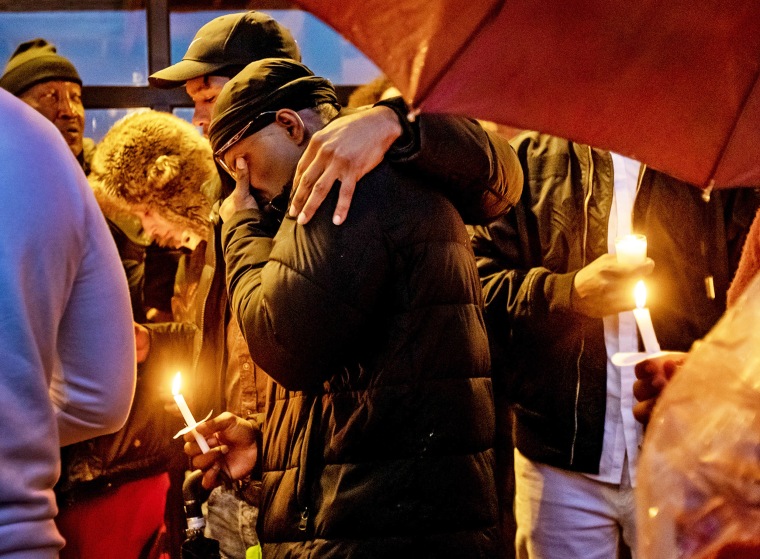 Family members console each other at a vigil for Keenan Anderson