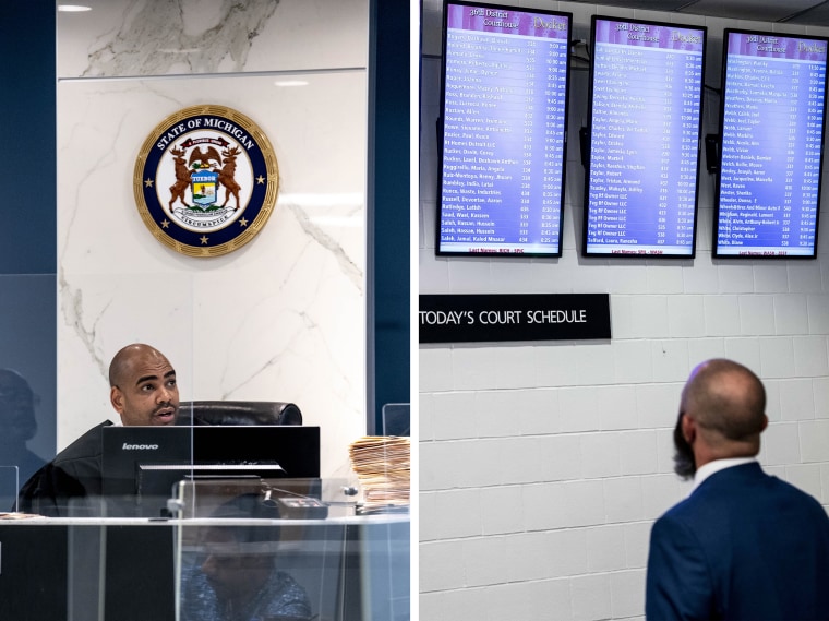 Judge Adam Sabree holds housing court, and a man checks a schedule, in the 36th District Court in Detroit on June 5, 2023.