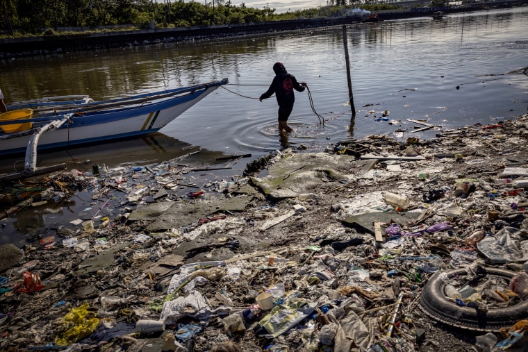 A fisherman docks his boat at a beach filled with plastic waste at Freedom Island in Paranque, Philippines on April 19, 2023.
