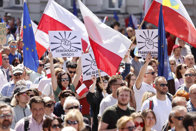 People attend an anti-government demonstration in Warsaw, Poland
