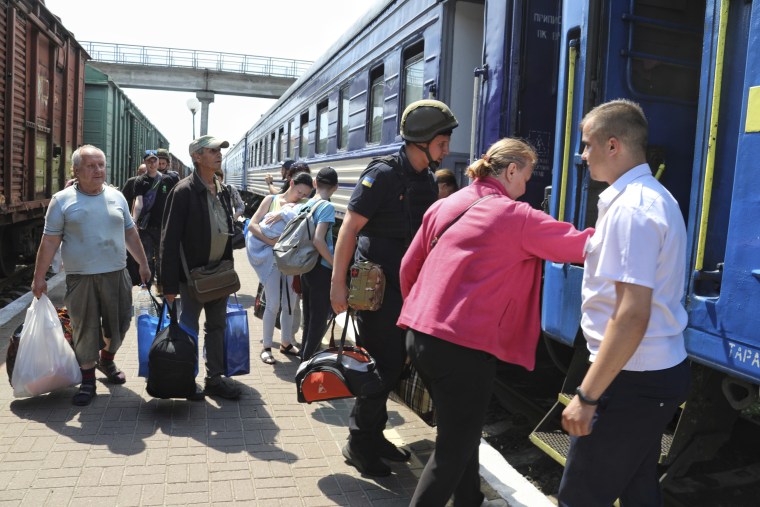 People board an evacuation train at a railway station in Kherson, Ukraine