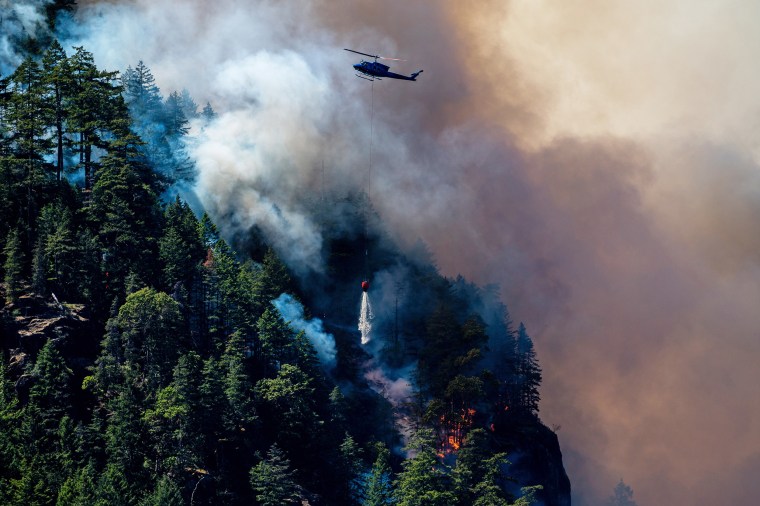 A helicopter drops water onto the Cameron Bluffs wildfire near Port Alberni, Canada