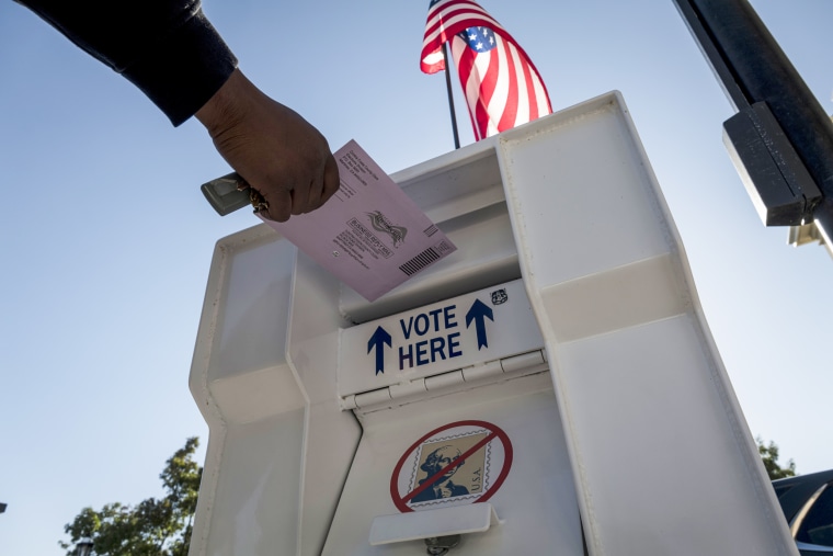 A voter drops an early voting ballot into a collection box in Martinez, Calif., on Oct. 27, 2020.