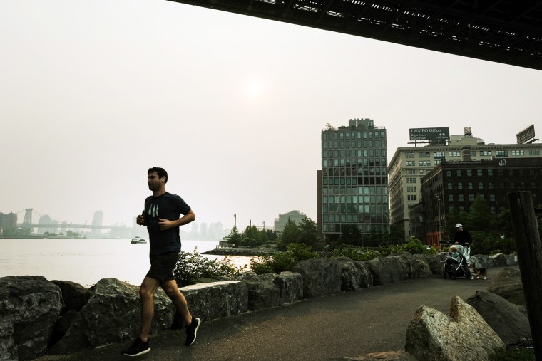 A person runs in Brooklyn, N.Y., on a hazy morning resulting from Canadian wildfires on June 6, 2023.