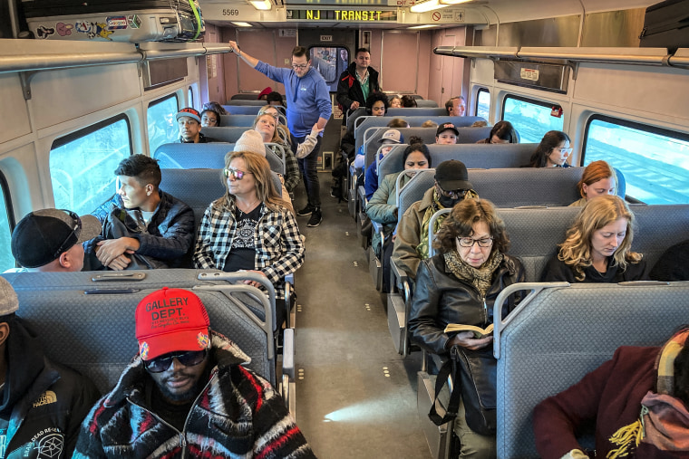 People ride a New Jersey Transit train in Secaucus, N.J., traveling into Penn Station, New York on April 3, 2023.