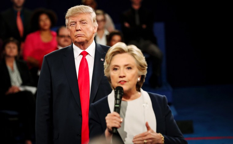 Then-Republican presidential nominee Donald Trump listens as Democratic nominee Hillary Clinton answers a question from the audience during their town hall debate at Washington University in St. Louis in 2016.