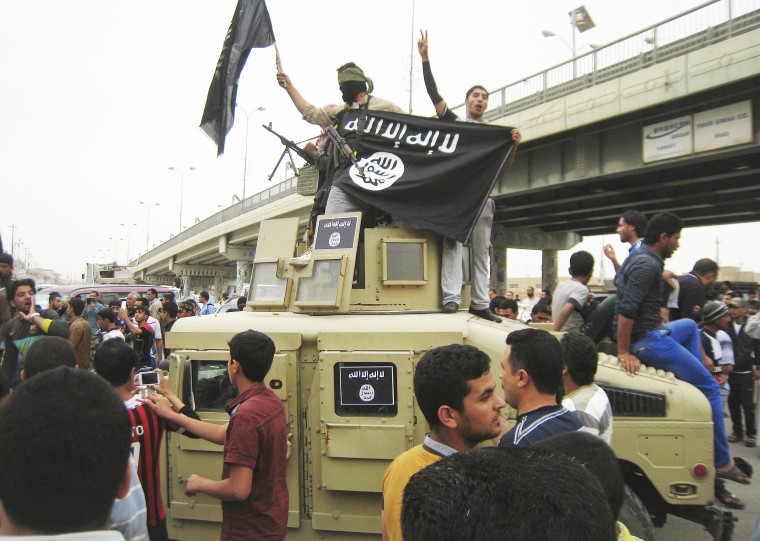 Islamic State group militants patrol Fallujah, Iraq in a commandeered Iraqi military vehicle