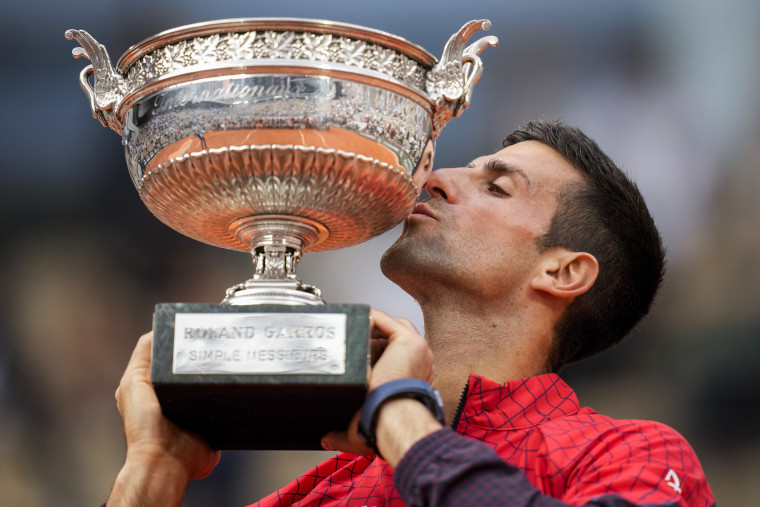 Novak Djokovic kisses the trophy as he celebrates winning the French Open tennis tournament in Paris on June 11, 2023.