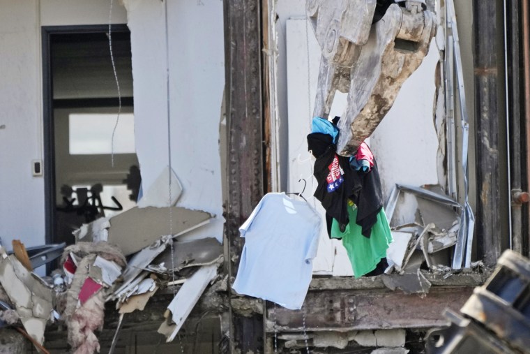 Clothing is removed from a closet during demolition at the site of a building collapse on June 12, 2023, in Davenport, Iowa. 