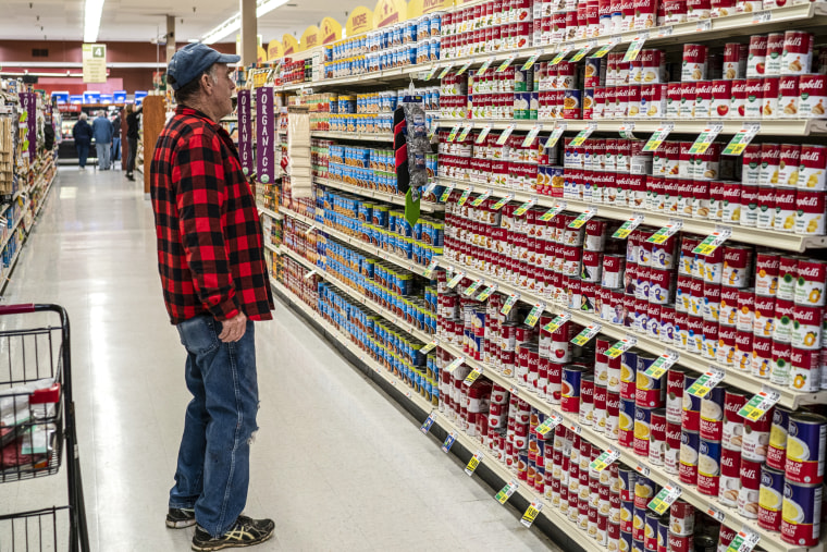 A shopper looks over a selection of canned soups April 30, 2023 at the Tops Super Market in Greenville, N.Y.
