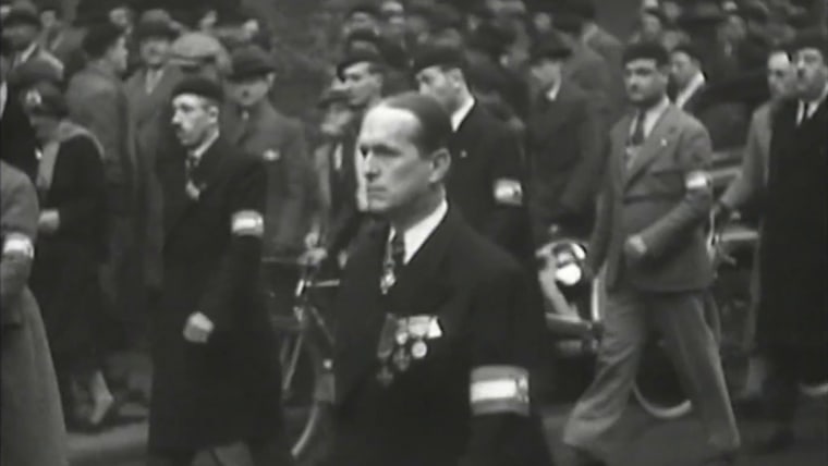 A frame from a newsreel shows Colonel François de la Roque marching with members of the Croix de Feu.