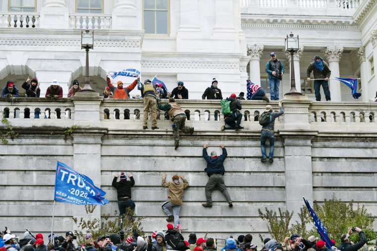 Supporters of President Donald Trump climb the west wall of the the Capitol on Jan. 6, 2021.