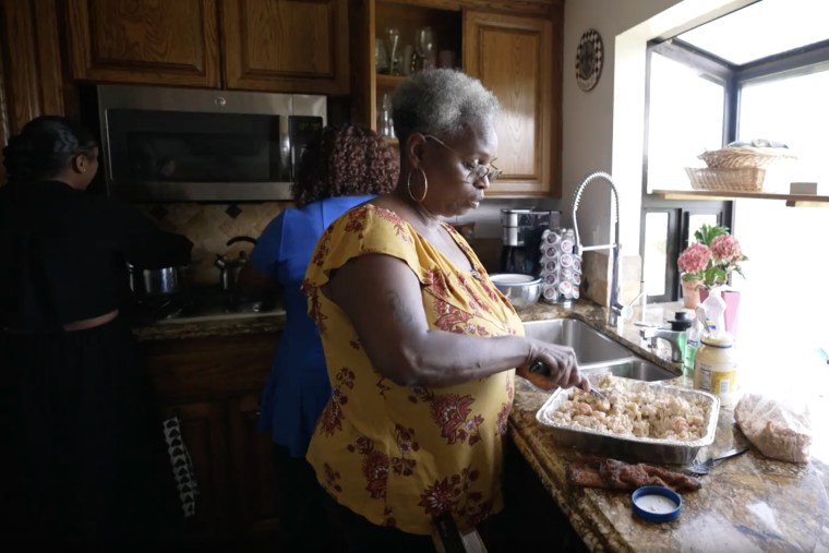 Marian Johnson prepares a potluck dinner with family members at her brother’s house in Oakland, Calif.