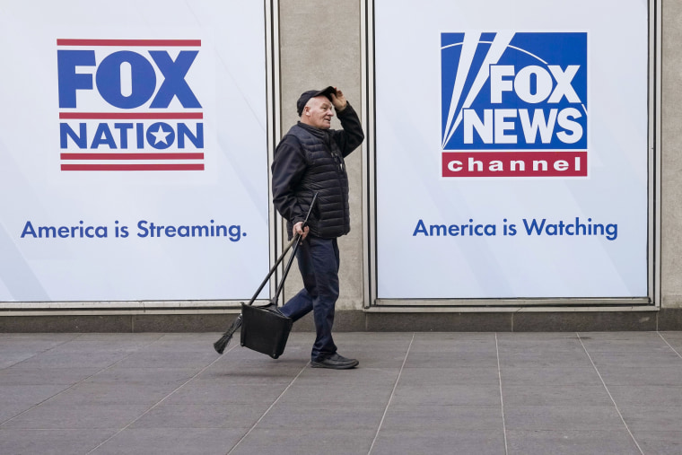 A man walks past the News Corp. Building and Fox News Headquarters on April 19, 2023, in New York. 