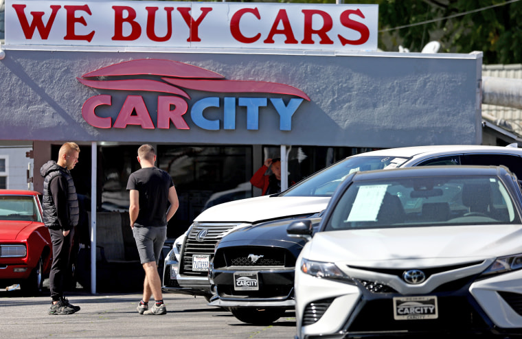 Customers browse in a used car lot on Feb. 15, 2023 in Glendale, Calif. 