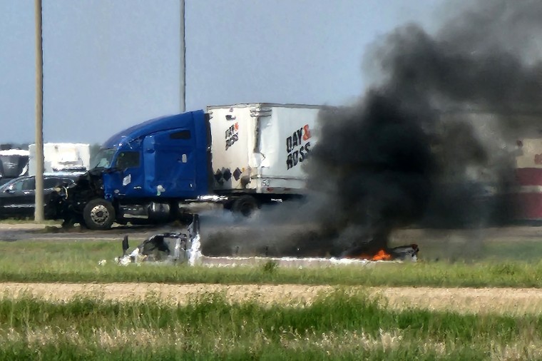 Smoke comes out of a car following a road accidente that left 15 dead near Carberry, west of Winnipeg, Canada on June 15, 2023. At least 15 people died June 15, 2023 in a road accident in central Canada's Manitoba province, local media reported. Canadian police said on Twitter that officers were responding to a "mass casualty collision" near the town of Carberry, west of Winnipeg, and that first responders and other Royal Canadian Mounted Police units were on the scene.