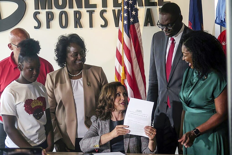 Image: Michigan Gov. Gretchen Whitmer signs Crown Act legislation on June 15, 2023 in Lansing, Mich., that will outlaw race-based hairstyle discrimination in workplaces and schools.
