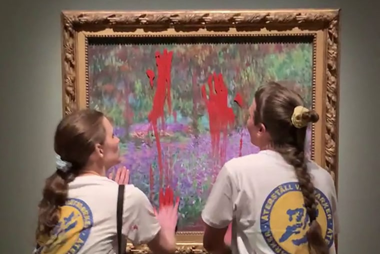 Two activists smear paint on the painting "The Artist's Garden at Giverny" by Claude Monet at the National Museum in Stockholm, Sweden.