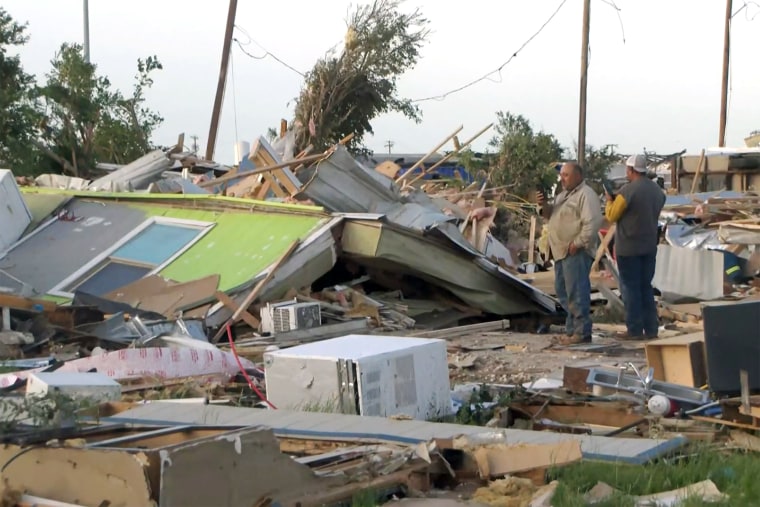 People survey tornado damage in Perryton, Texas on June 15, 2023.