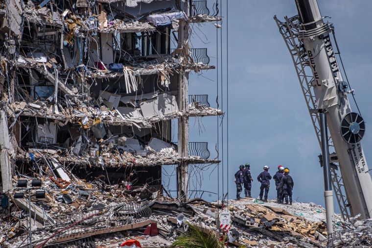 Members of the South Florida Urban Search and Rescue team look for possible survivors in the partially collapsed Champlain Towers South condo building in Surfside, Fla.