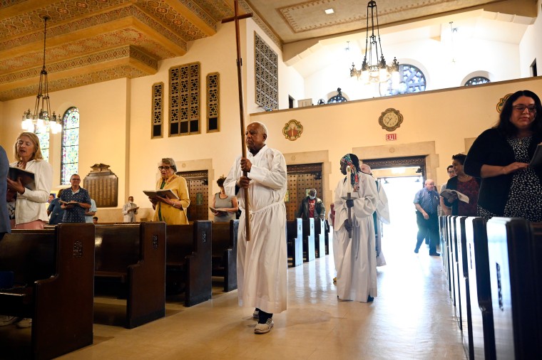 Sacristan Isaac Tedla leads a procession at the start of Mass,   at Gesu Catholic Church in Detroit. on June 18, 2023.