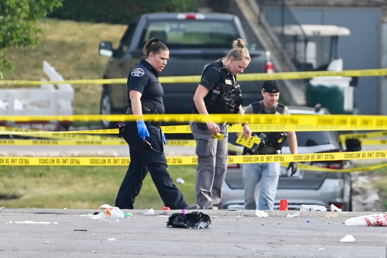 Investigators look over the scene of an overnight shooting at a strip mall in Willowbrook, Ill., on June 18, 2023. 