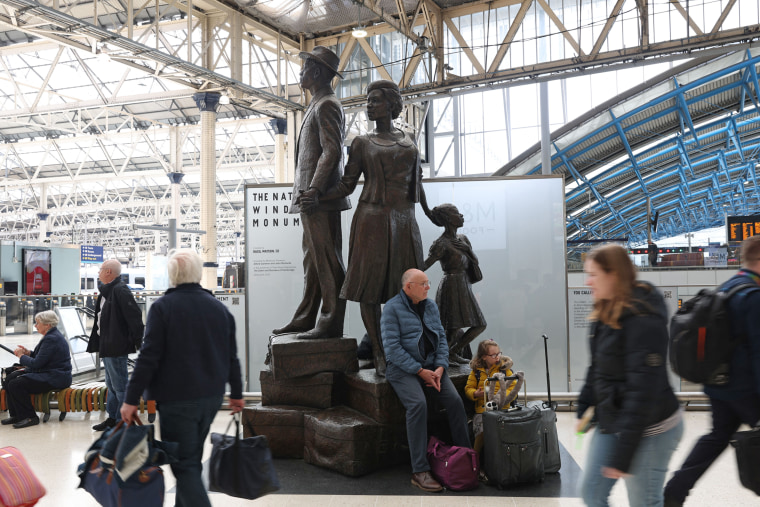 Passengers walk past the National Windrush Monument by Jamaican artist Basil Watson at Waterloo Station in London on April 6, 2023.