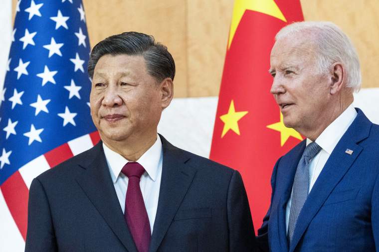 Chinese President Xi Jinping and President Joe Biden stand in front of an American flag and a Chinese flag at the G20 summit meeting