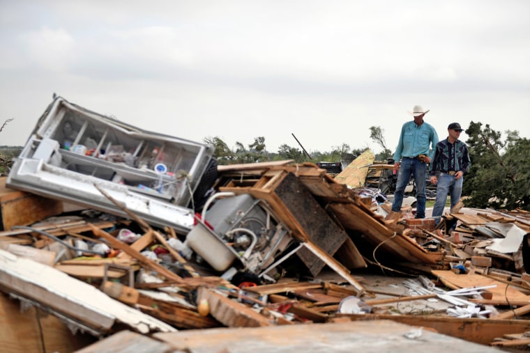 Residents pick up debris after a tornado, Thursday, June 22, 2023, in Matador, Texas.